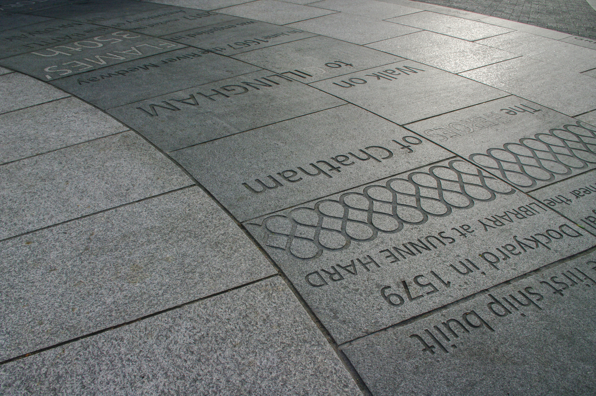 sandblasted text and pattern work in grey granite paving